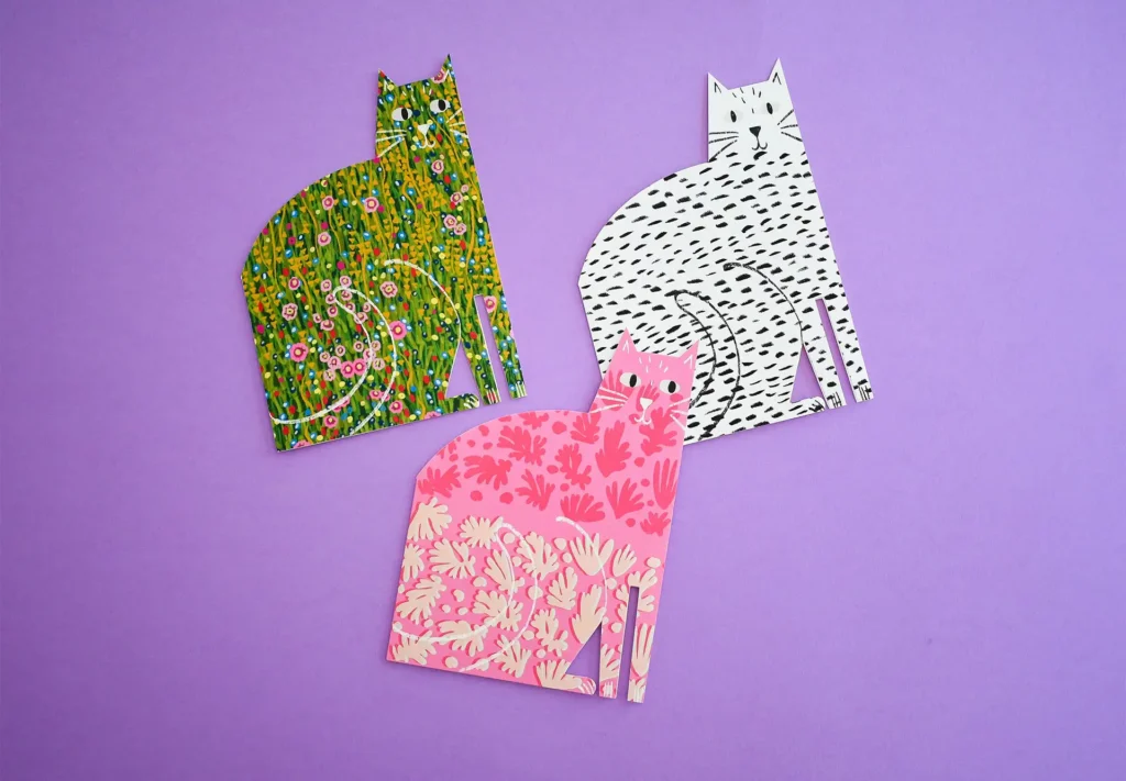 A collection of creative greating cards cut to the shape of cats.