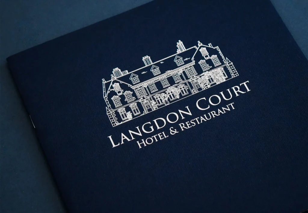 The front cover of a brochure printed for Langdon Court Hotel & Restaurant, showcasing a foil illustration of the hotel, adding an elegant and captivating touch.