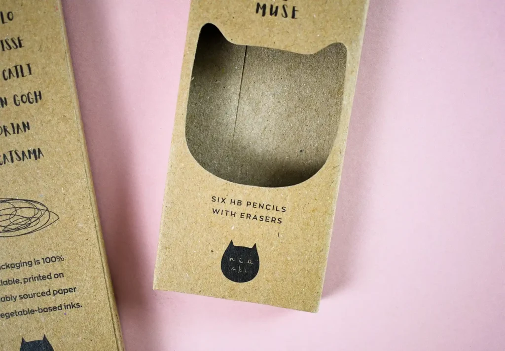 A close-up view of a creative crayon box featuring a window in the shape of a cat's head, adding a playful and whimsical touch to the packaging design.