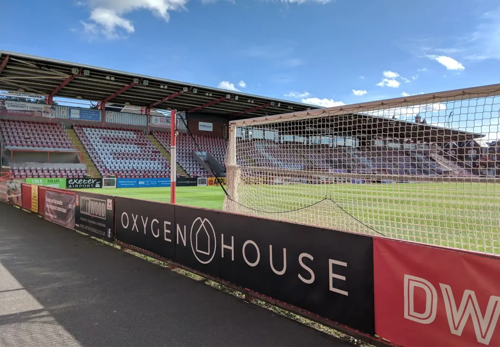 A large sign along the side of a football pitch.