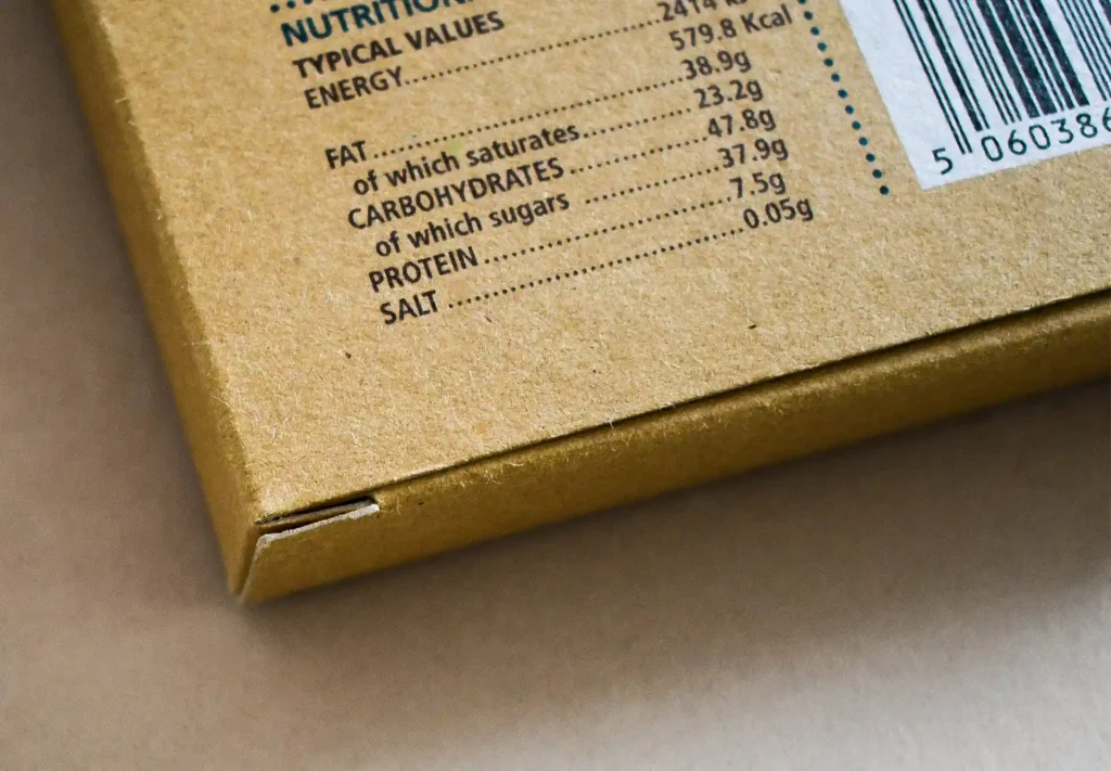 A close-up photograph showcasing the ingredients listed on the back of custom chocolate bar packaging, highlighting the exceptional print detail achieved on kraft card.