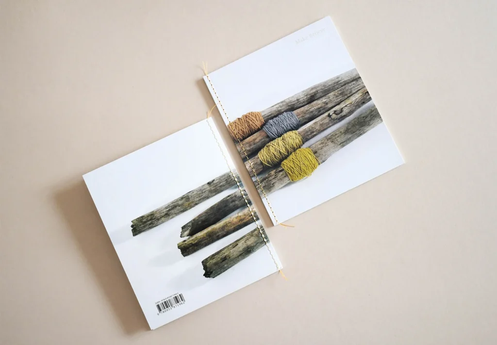 The front and back of a bespoke brochure featuring a distinctive yellow string stitched binding, adding a unique finishing touch.