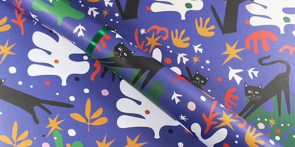 Custom wrapping paper featuring fun illustrations of cats and Christmas inspired shapes.